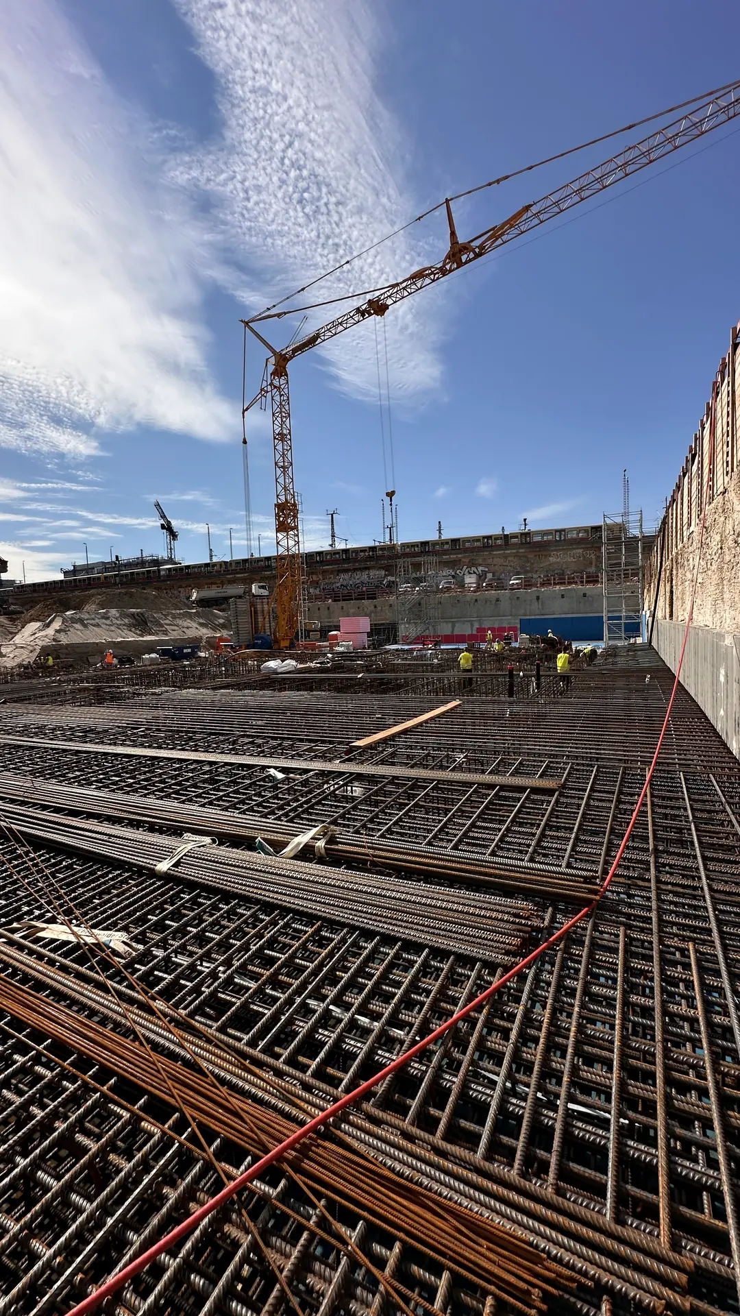 Laid rebar mats on a construction slab, a crane beyond