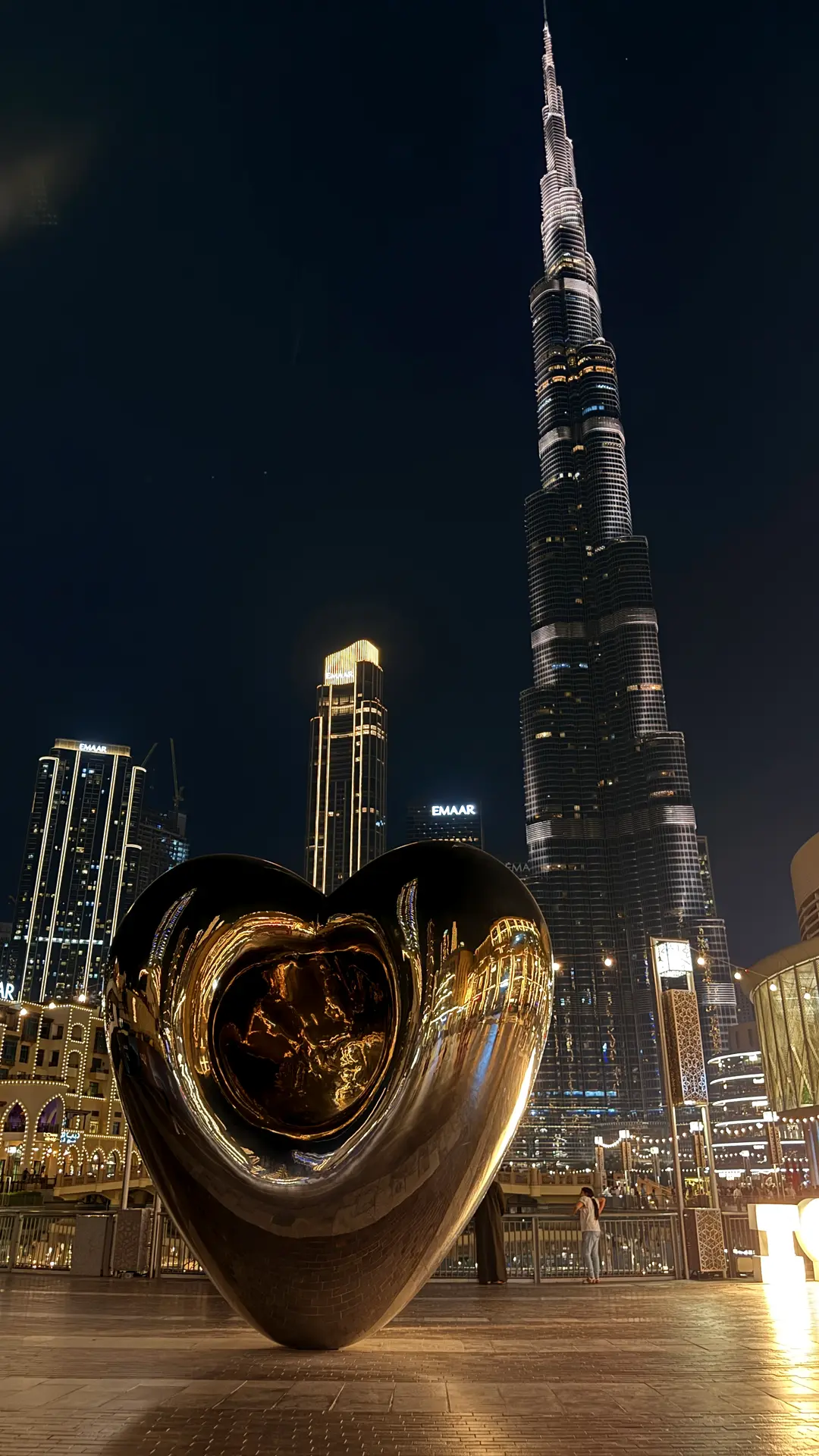 Burj Khalifa bei Nacht, im Vordergrund eine spiegelnde Herz-Skulptur