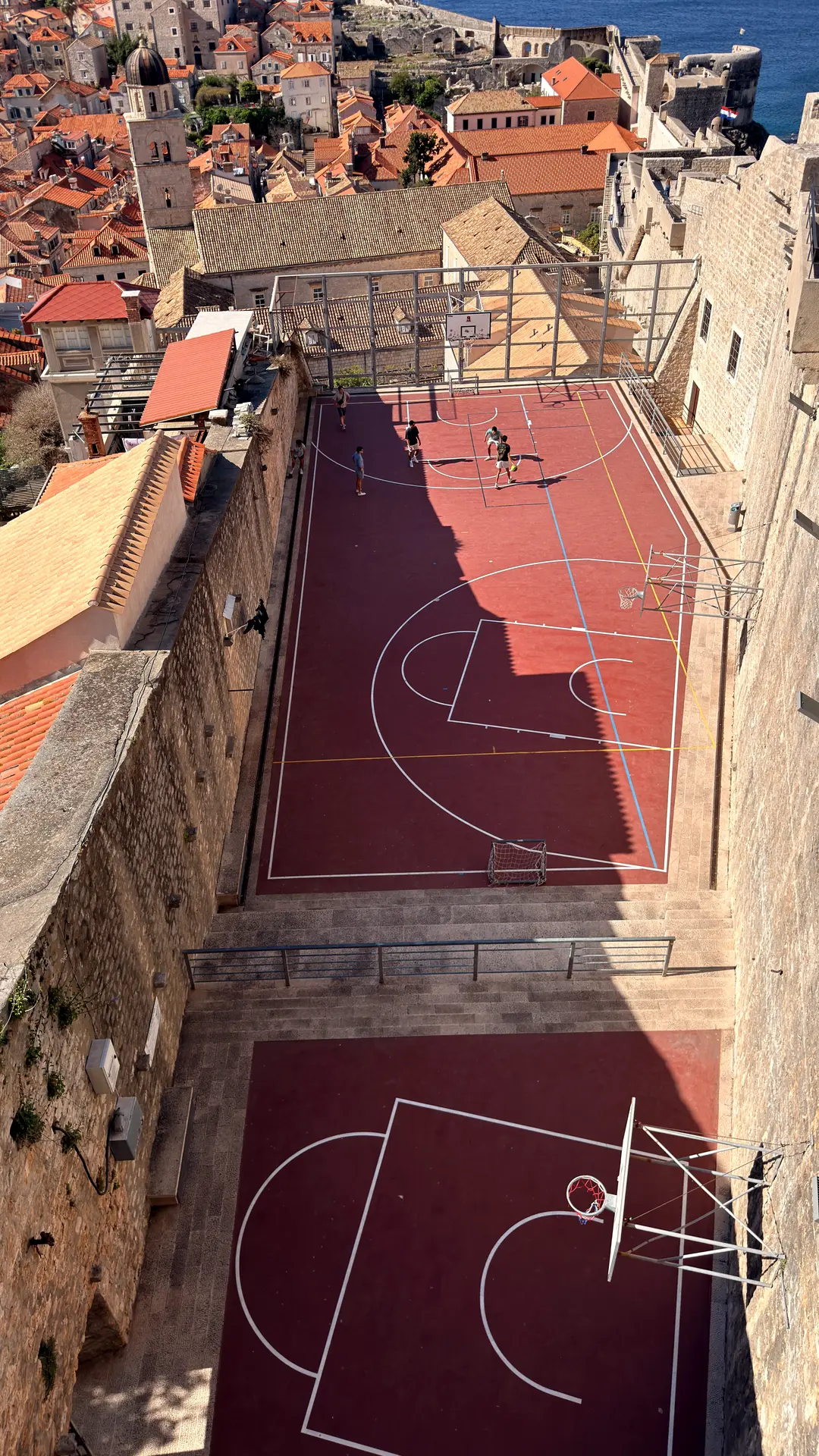 Rote Basketballfelder zwischen Altstadtmauern von Dubrovnik, von der Stadtmauer aus gesehen