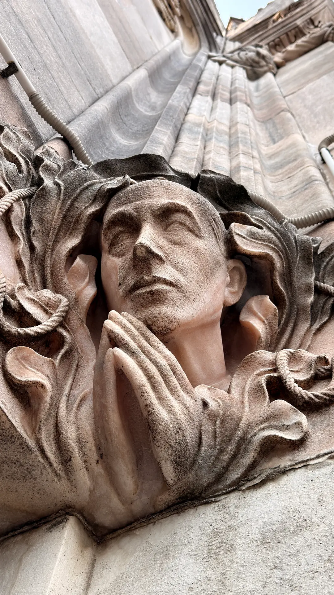 Steinrelief eines betenden Gesichts an der Fassade des Mailänder Doms