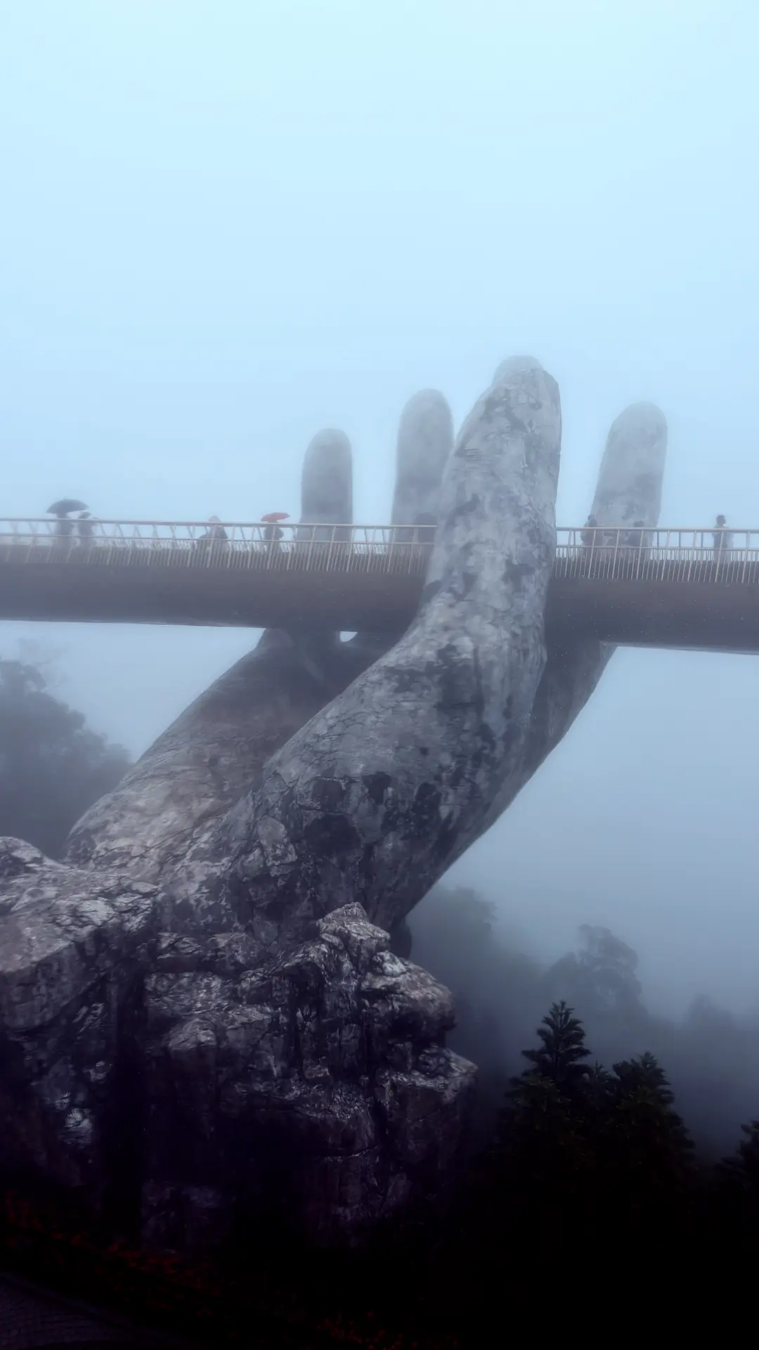 Riesige steinerne Hand trägt die Goldene Brücke im Nebel der Ba Na Hills