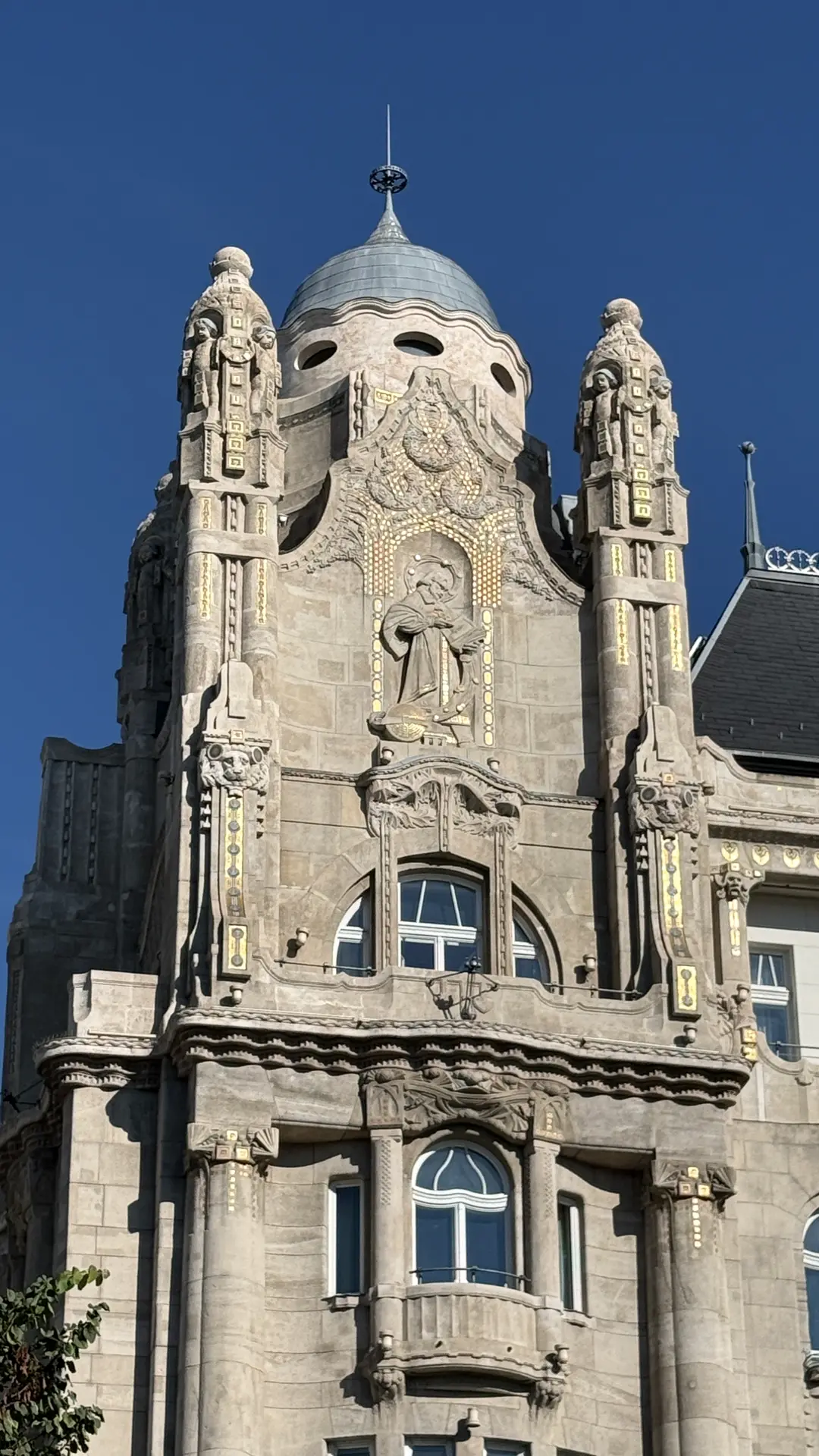 Jugendstil-Fassade des Gresham Palace mit Turm und Kuppel vor blauem Himmel