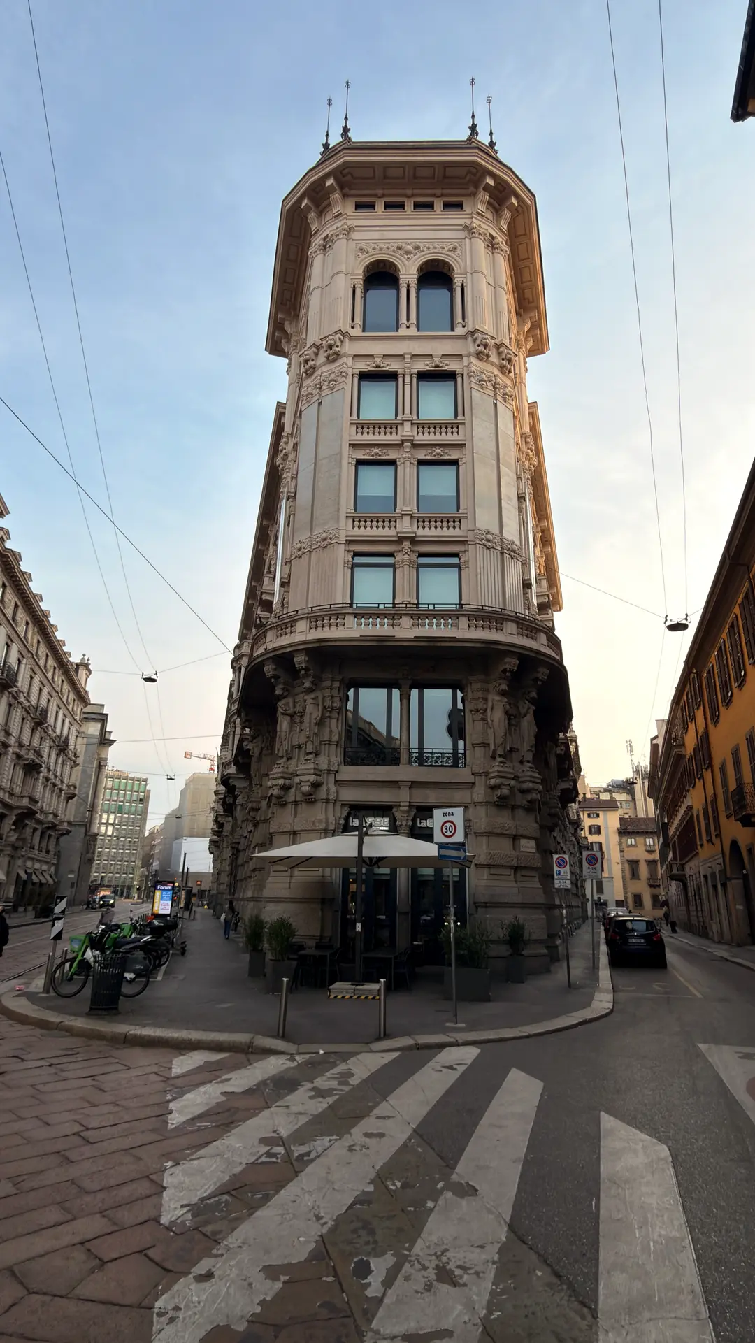 Schmales historisches Eckhaus mit Turmaufsatz in einer Mailänder Straßenkreuzung