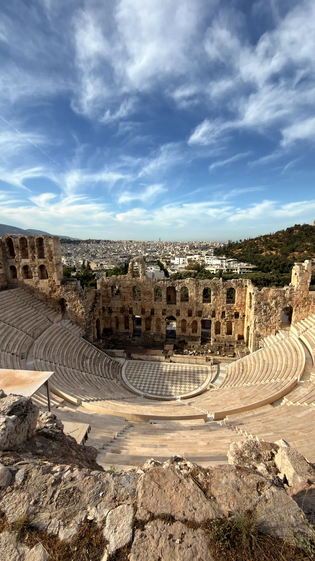 Blick von oben in das antike Theater Odeon des Herodes Atticus, dahinter das Häusermeer Athens