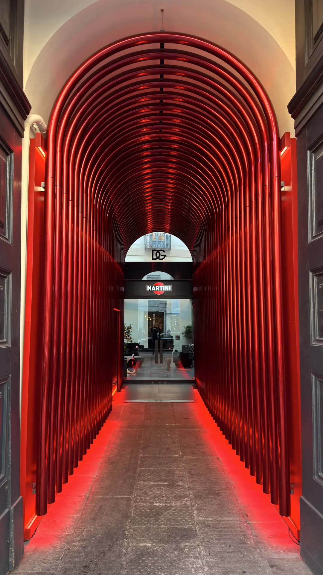 Begehbare Installation aus roten Bögen, die einen leuchtenden Tunnel formen