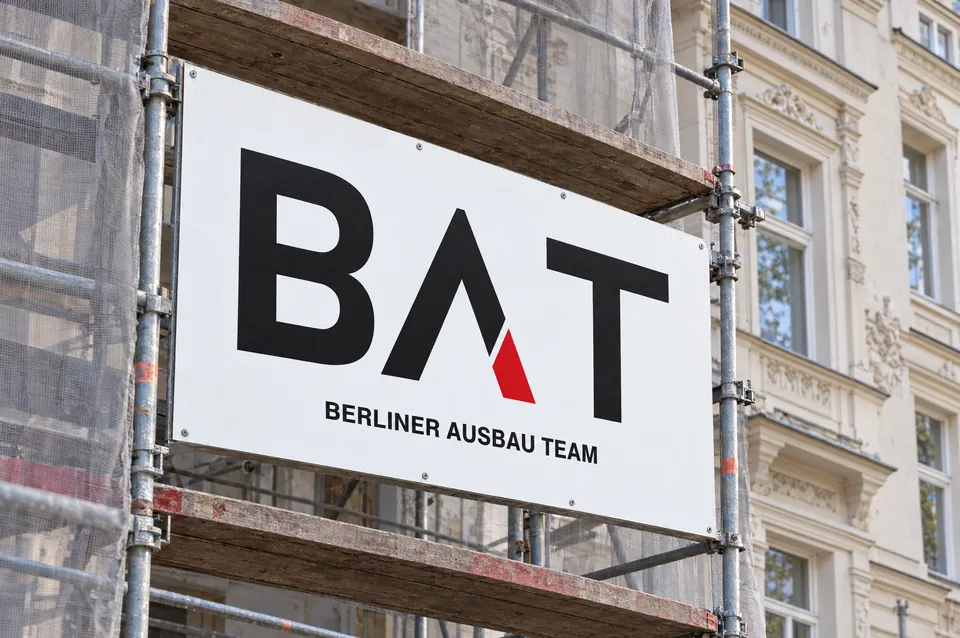 Bauschild mit dem BAT-Logo an einem eingerüsteten Berliner Altbau