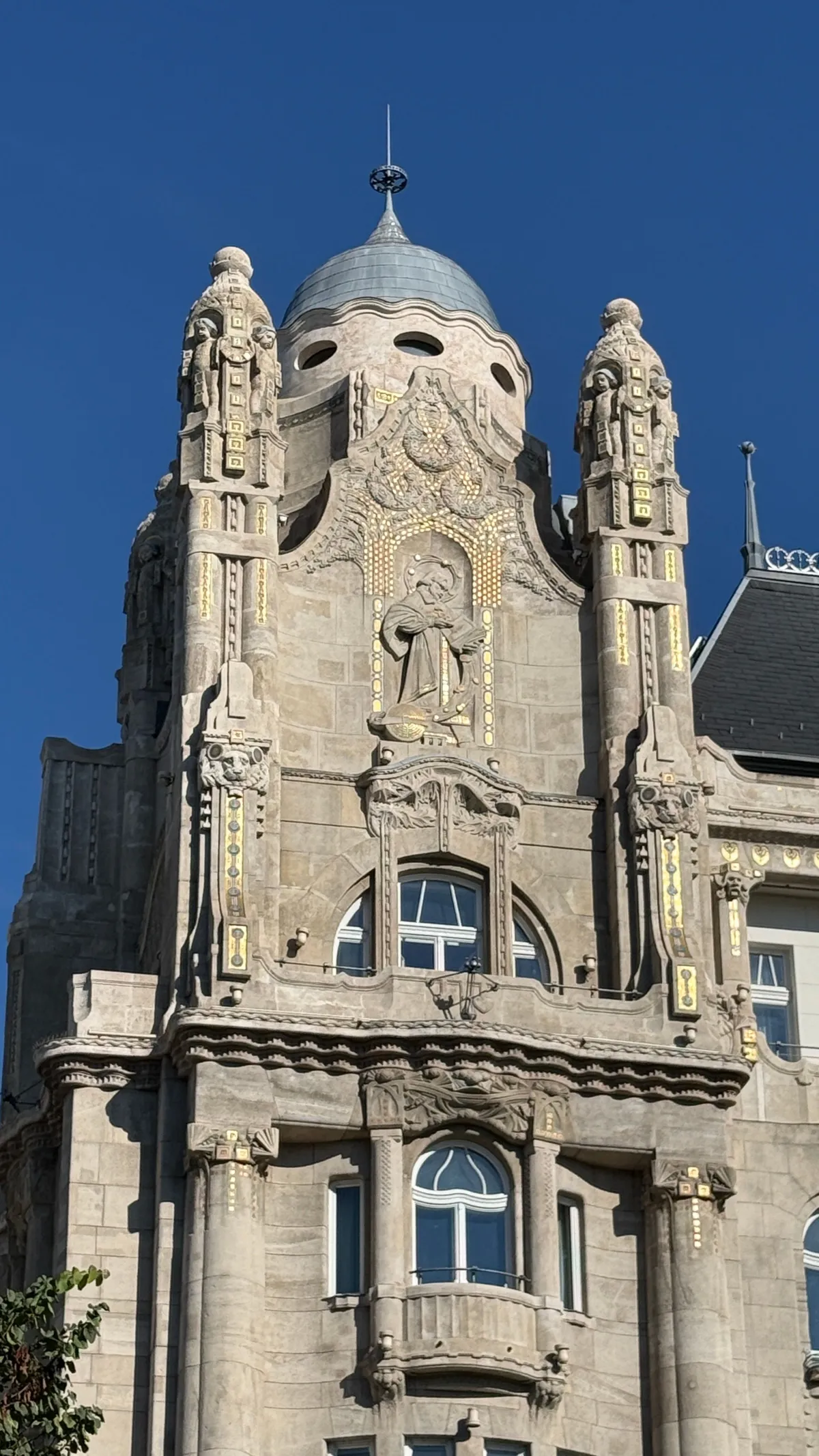 Art nouveau facade of the Gresham Palace with tower and dome against a blue sky