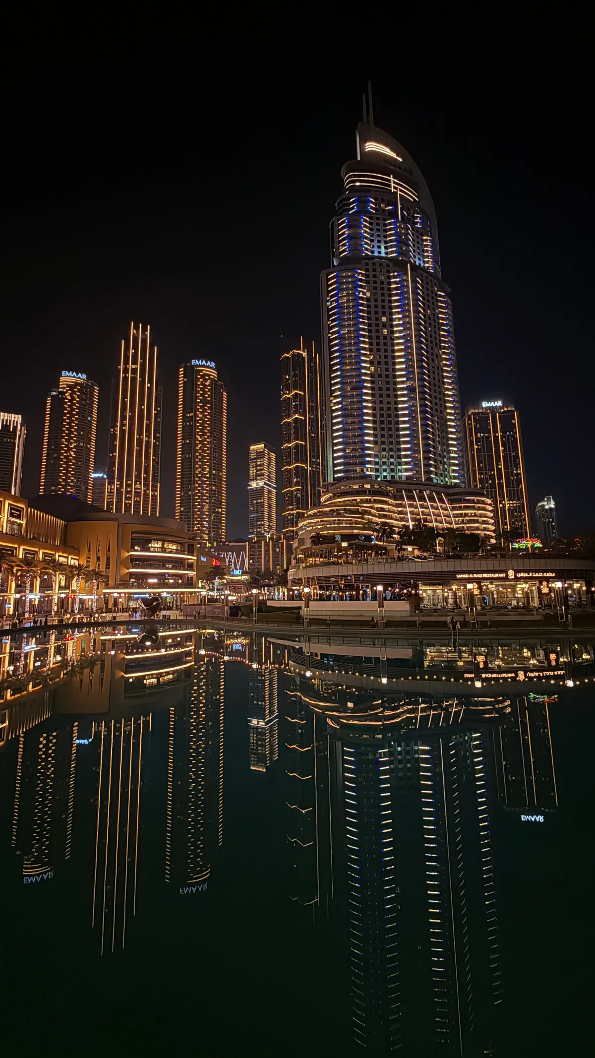 Illuminated Downtown Dubai towers reflected in the lagoon at night