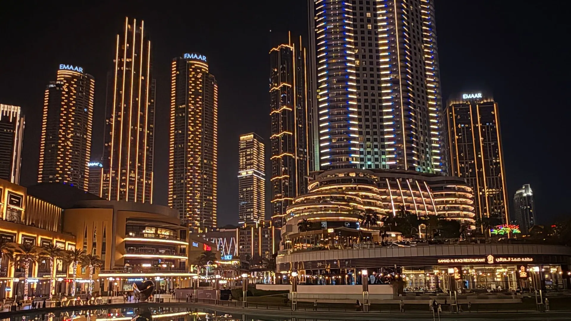 Illuminated Downtown Dubai towers reflected in the lagoon at night