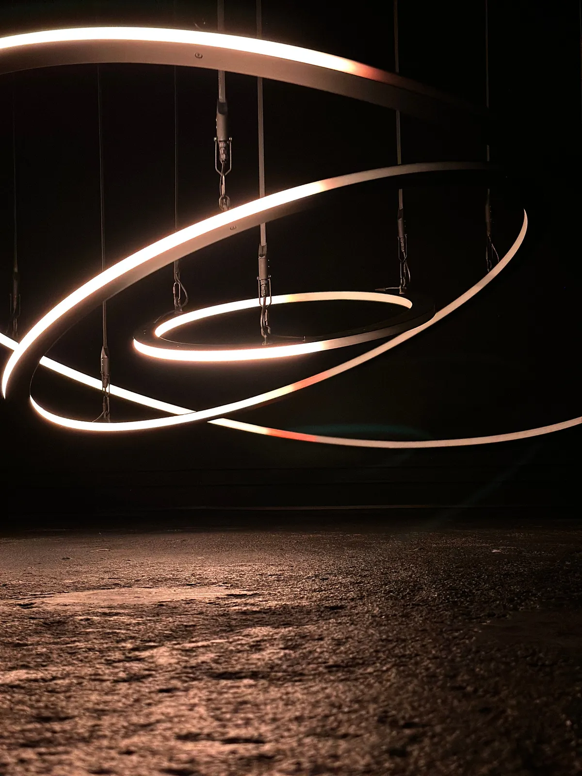 White neon lines looping across a dark concrete wall