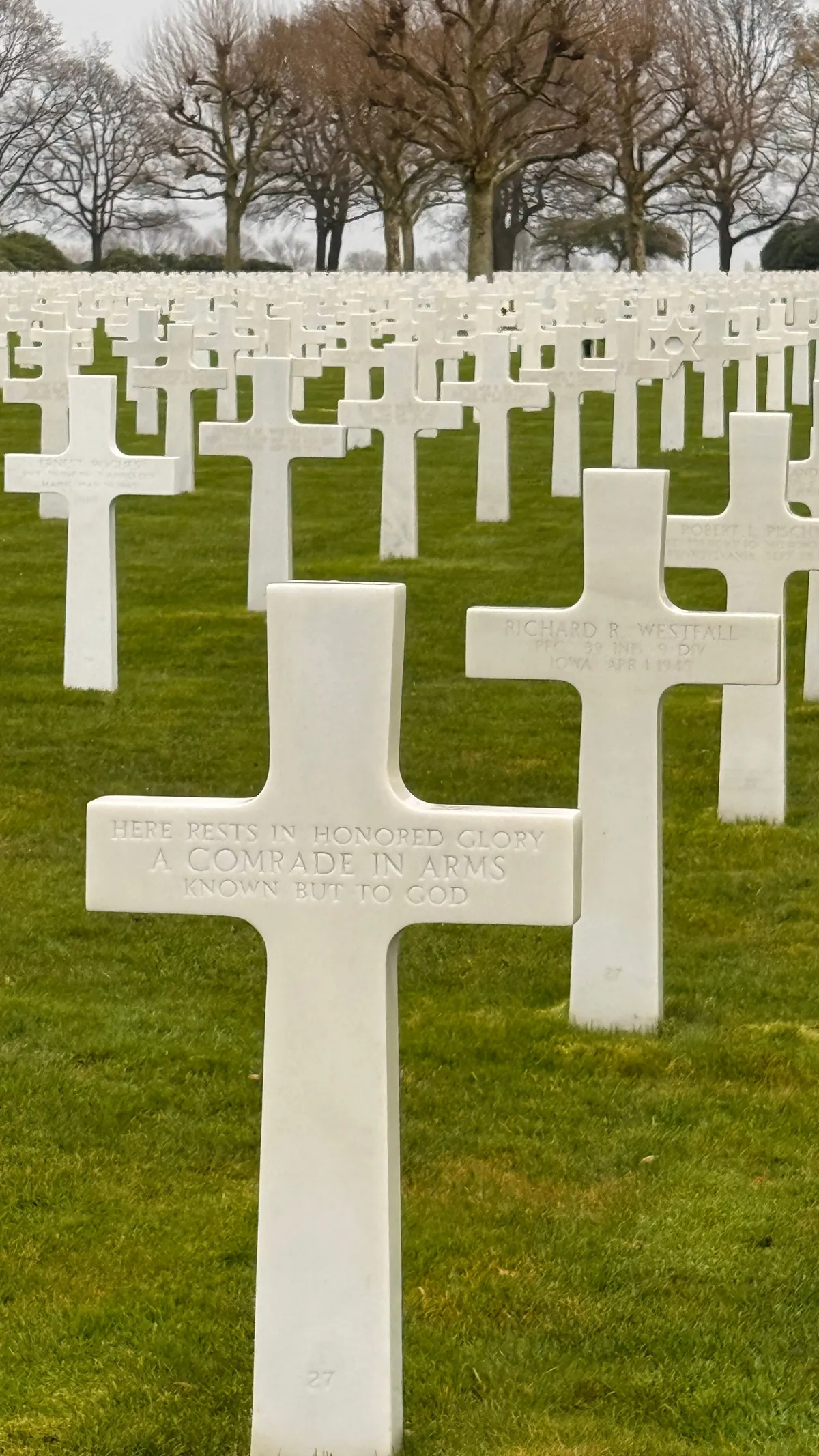 Rows of white marble crosses on a lawn at the Netherlands American Cemetery in Margraten