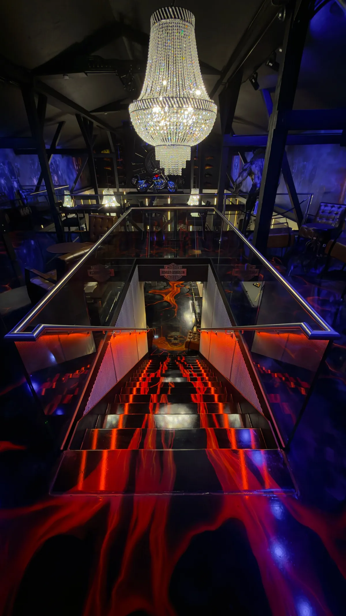 Crystal chandelier above a black staircase with a red-orange flame-painted floor