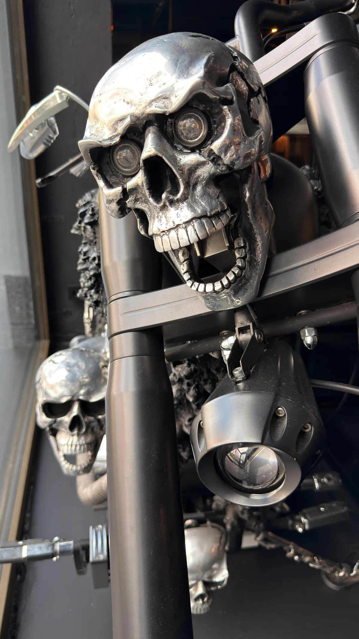 Chrome skulls mounted on the frame of a black motorcycle