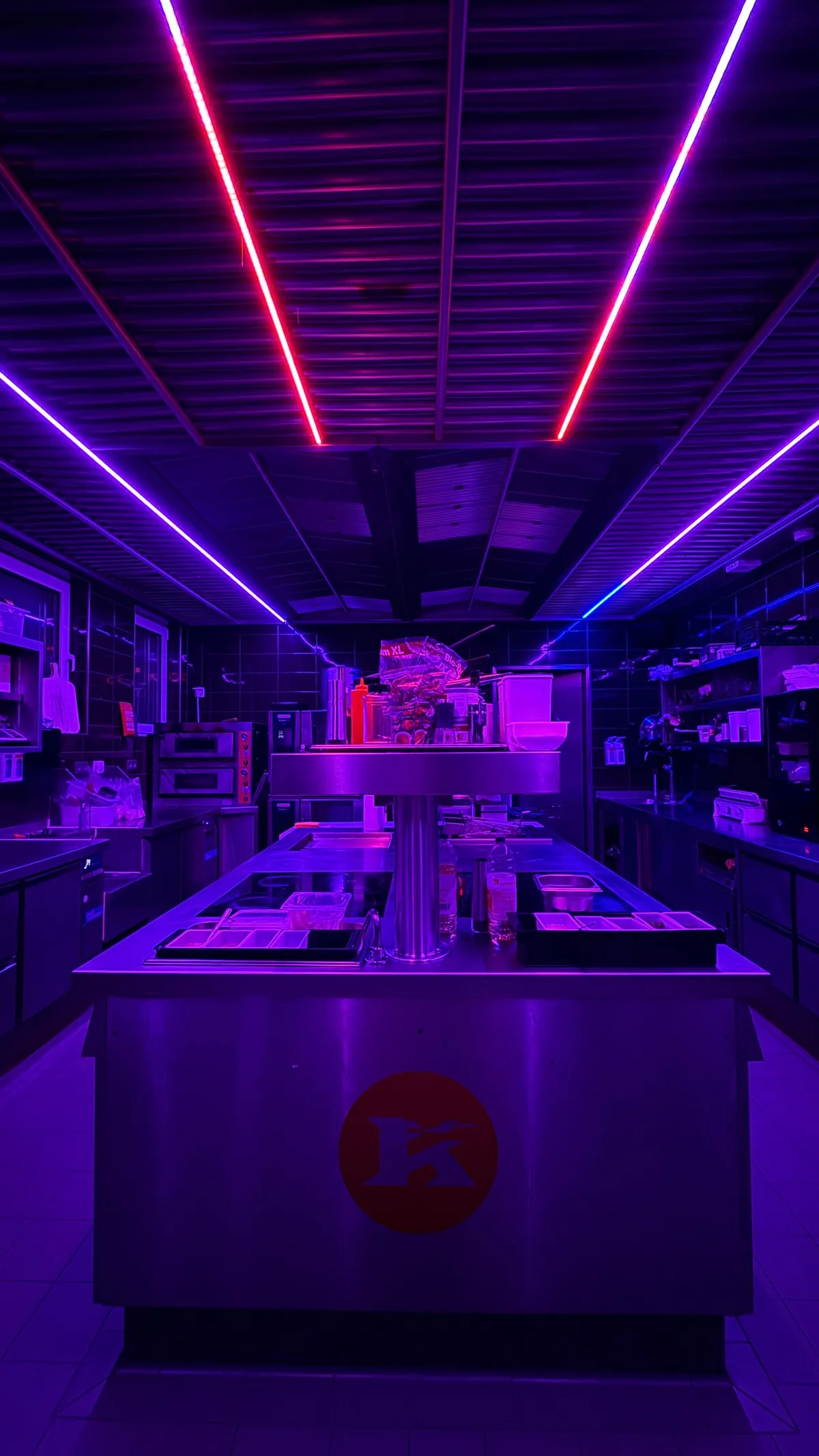Stainless-steel kitchen bathed in violet and red neon light